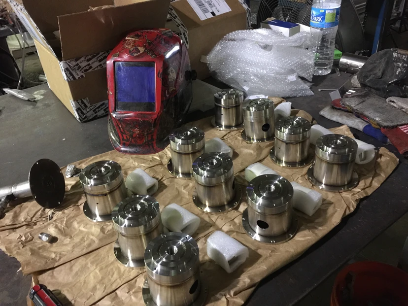 Machined flanges and components with welding helmet — industrial fabrication and millwright services by Anton Installers Inc.